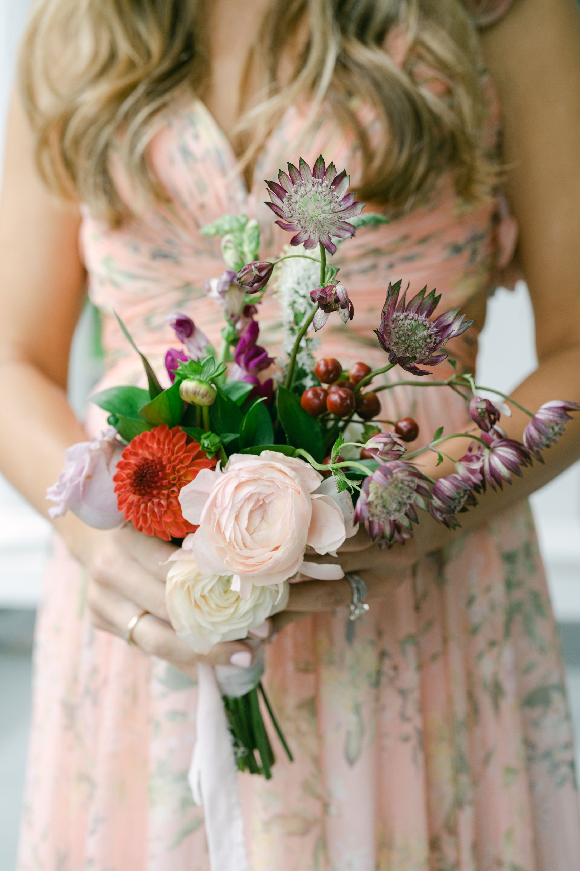 Garden-style bridal bouquet with blush and burgundy blooms.